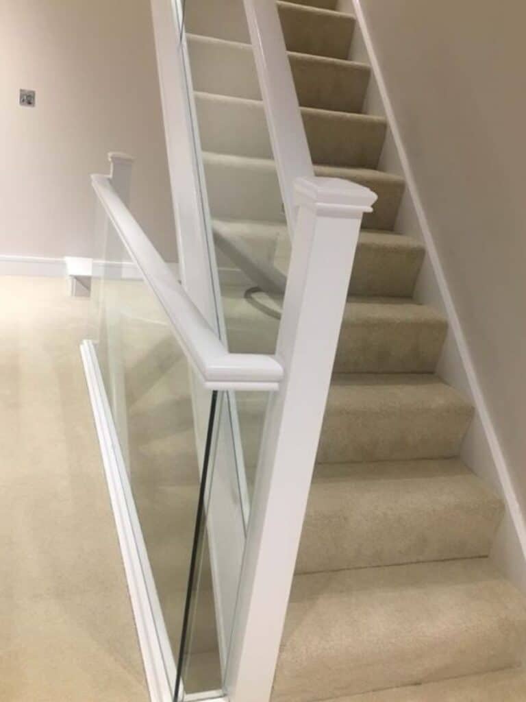 Glass balustrade staircase with wooden frame and handrail